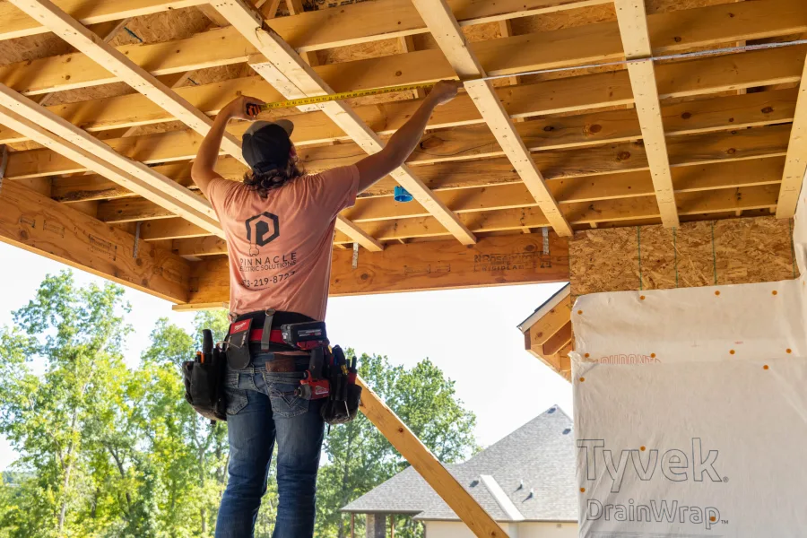 Electrician wiring a ceiling in a home under construction